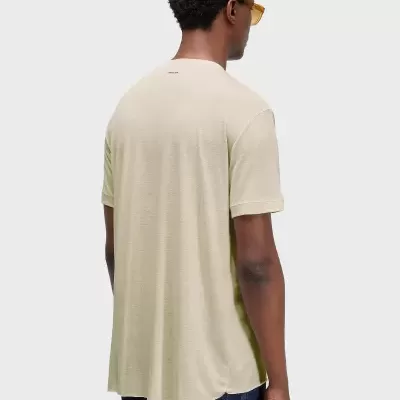 Homem de costas a usar t-shirt bege com logo OSKLEN