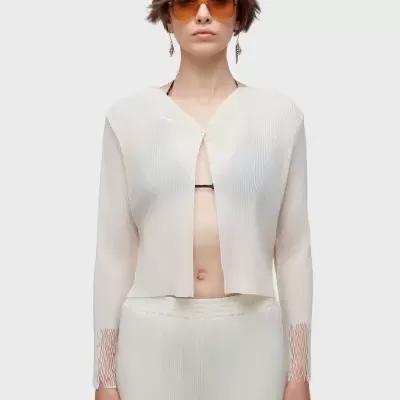 Conjunto creme plissado com calças e blusa manga longa e óculos de sol laranja