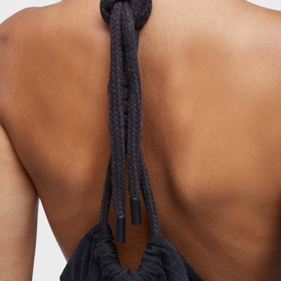 Costas femininas com cordão preto trançado amarrado de peça de roupa