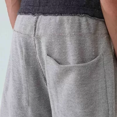 Parte traseira de calças ou calções cinzentos com bolso e cintura escura desfiada