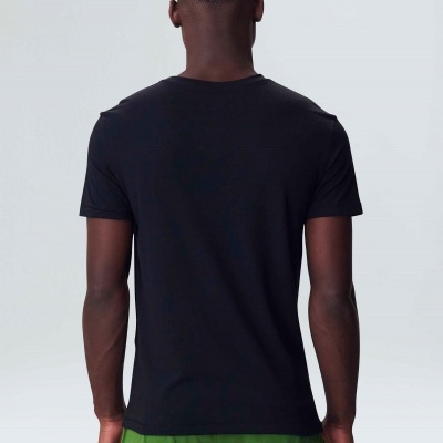 Pessoa de costas com t-shirt preta e calças verdes