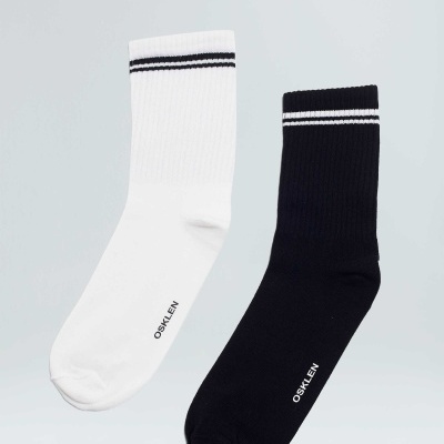 Par de meias branca e preta com riscas e palavra OSKLEN