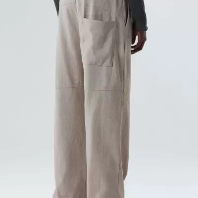 Calças largas bege com bolso exterior usadas por modelo de costas