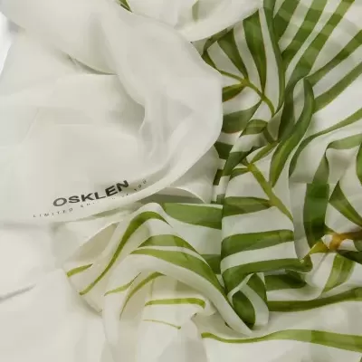 Lenço branco com padrão de folhas verdes e logo OSKLEN