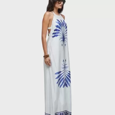 Vestido longo branco com padrões azuis e alças finas em mulher com óculos escuros