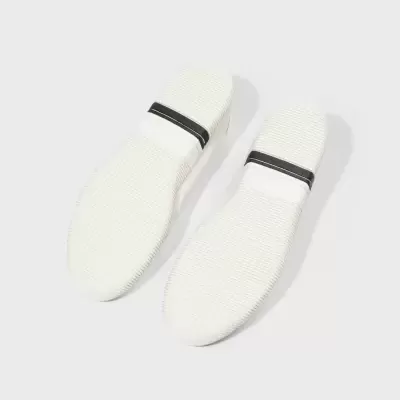 Solas de sapatos brancos com faixa preta e branca no calcanhar