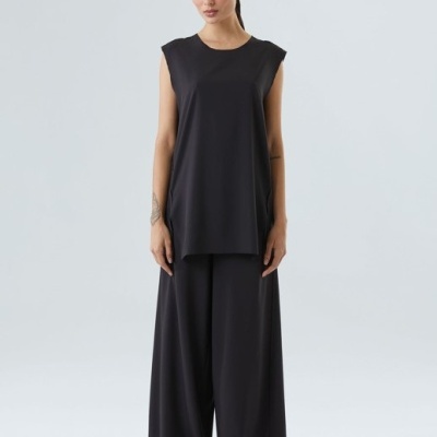 Conjunto feminino preto com calças largas e camisa sem mangas, fundo branco