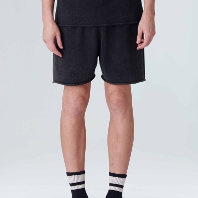 Calções pretos, meias pretas com riscas brancas, calçado desportivo preto com sola clara