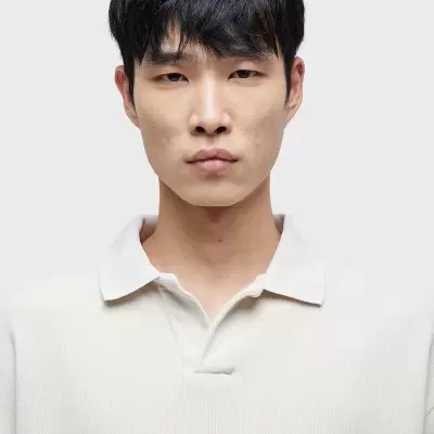 Camisola branca de malha com gola de polo usada por modelo