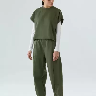 Conjunto de roupa casual feminino verde e branco com calças largas e sapatilhas brancas.