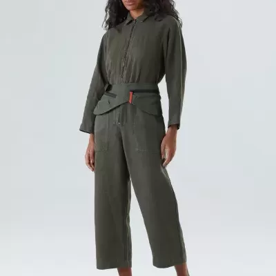 Mulher com macacão verde-oliva e cinto preto com detalhe vermelho