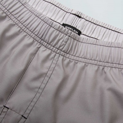 Calças desportivas cinzentas com elástico lilás e etiqueta OSKLEN