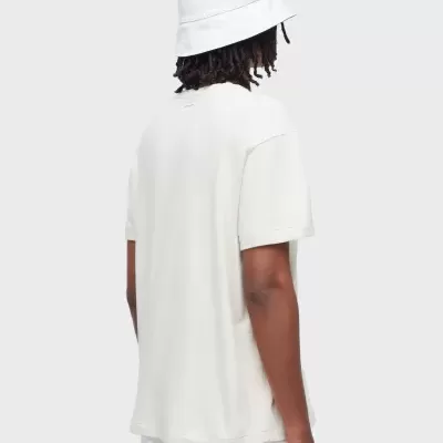 Pessoa de costas com chapéu branco e t-shirt bege