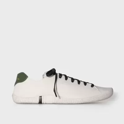 Tênis branco com sola branca, atacadores pretos e calcanhar verde com texto amarelo