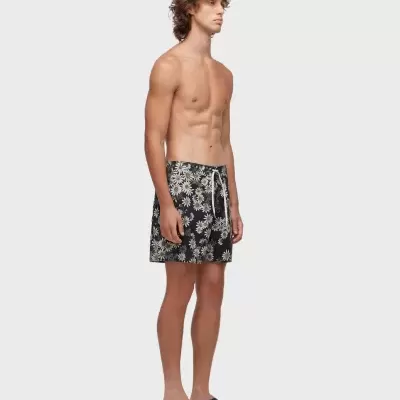Calções de banho masculinos pretos com flores brancas, modelo de pé