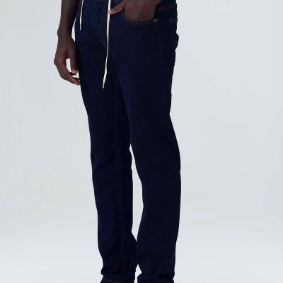 Calças de ganga azul-escuro com cinto de corda branca e sapatilhas bege