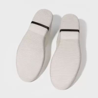 Solas de sapato brancas com faixa preta e padrão de linhas