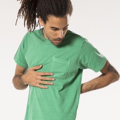 T-shirt verde com bolso frontal usada por homem com cabelo apanhado