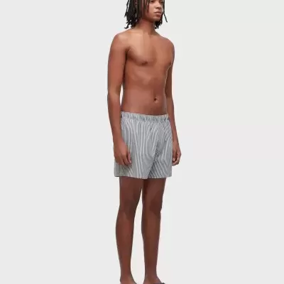 Homem com boxers cinza de riscas e chinelos pretos