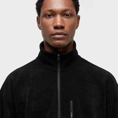 Homem com casaco preto com fecho e bolso frontal