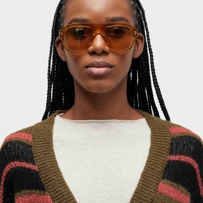 Óculos de sol castanhos com lentes escuras em modelo com cabelo trançado
