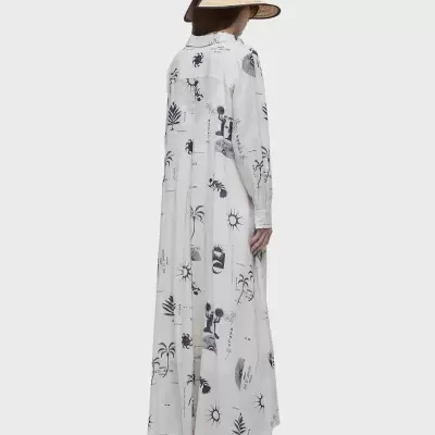 Vestido longo branco com estampas pretas visto de costas, mulher com chapéu rústico e sapatos brancos