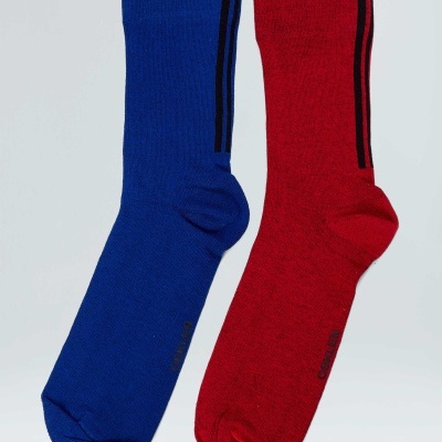Duas meias, uma azul e outra vermelha, com riscas pretas verticais na parte superior