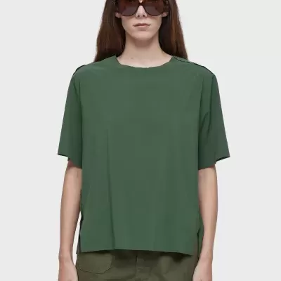 Mulher a usar t-shirt verde escuro e calções verdes com óculos de sol grandes