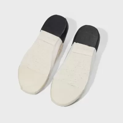 Chinelos brancos vistos por baixo com sola branca e preta