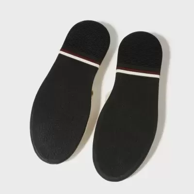 Solas pretas de sapatos com faixa branca e linha vermelha no calcanhar