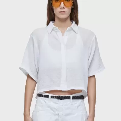 Mulher com camisa branca e óculos de lentes amarelas