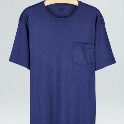 T-shirt azul escura com bolso frontal pendurada no cabide.