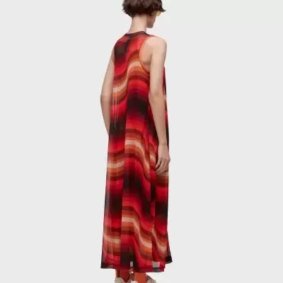 Vestido comprido com padrão em tons vermelhos em modelo feminino visto de costas