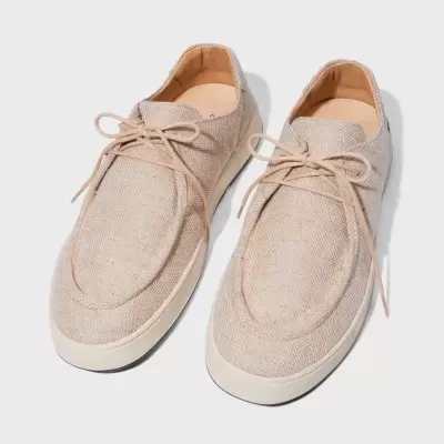 Sapatos masculinos em tecido bege claro com sola branca e atacadores.