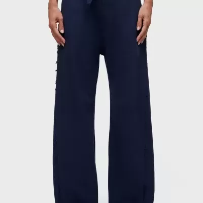 Calças largas azuis escuras com cordão no cós e sapatos brancos.