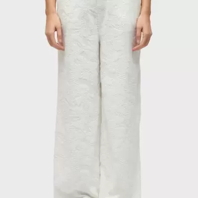 Calças brancas texturizadas com padrão floral e sandálias douradas