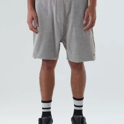 Calções cinza felpudos com cós escuro usados com meias brancas e pretas e sapatos pretos