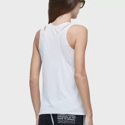 Pessoa de costas com top branco e calças pretas com texto no bolso