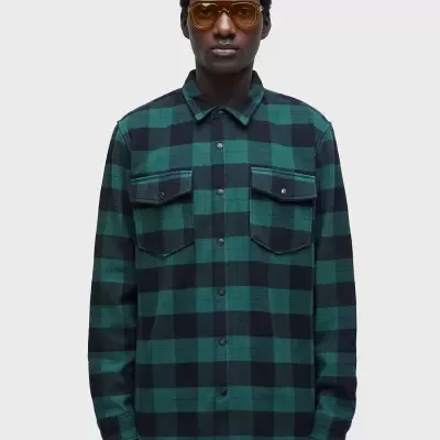 Camisa xadrez verde e preta de manga comprida com bolsos ao peito.