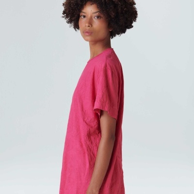 T-shirt feminina rosa em tronco de perfil com fundo branco.