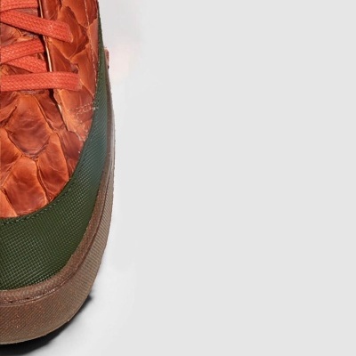 Parte frontal de ténis castanho e verde com padrão texturizado e atacadores castanhos