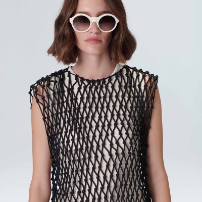 Mulher com óculos de sol brancos, top branco com rede preta