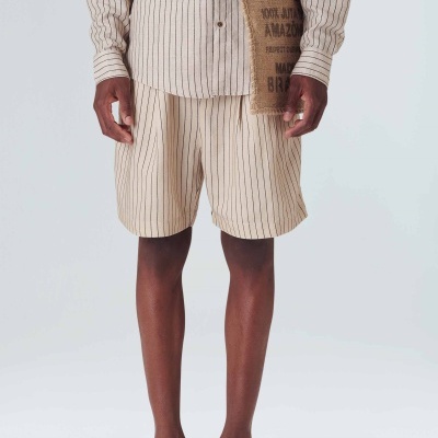 Conjunto masculino com camisa e calção cinza riscado, saco rústico pendurado e sandálias castanhas.