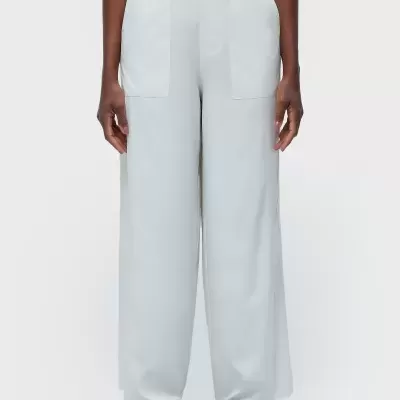 Calças brancas largas com bolsos frontais e sapatos pretos