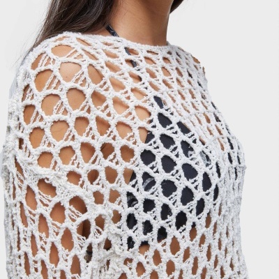 Malha branca de malha aberta sobre top preto vista ao nível dos ombros