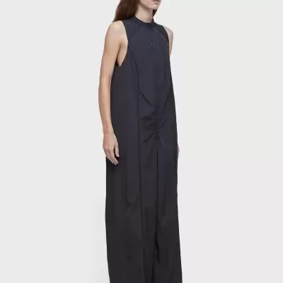 Vestido comprido preto sem mangas com ténis brancos e óculos escuros