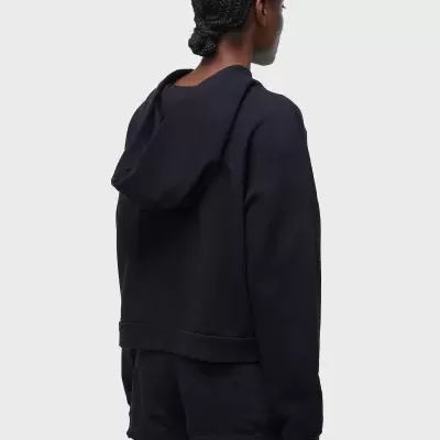 Pessoa de costas a usar sweat preta com capuz e calções pretos