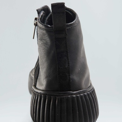 Bota preta com sola grossa canelada vista de trás