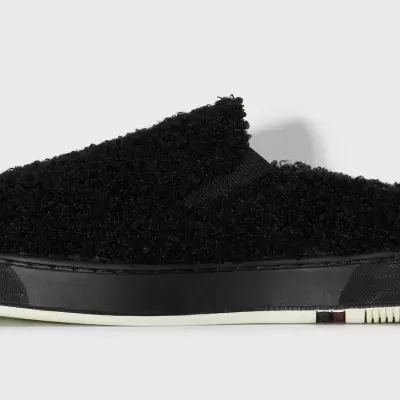 Tênis slip-on preto com textura felpuda e sola preta e branca