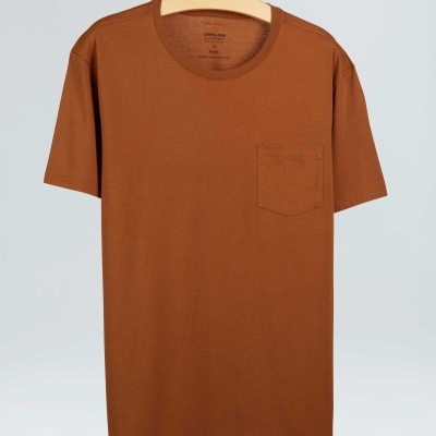 T-shirt castanha de manga curta com bolso no peito pendurada num cabide de madeira.